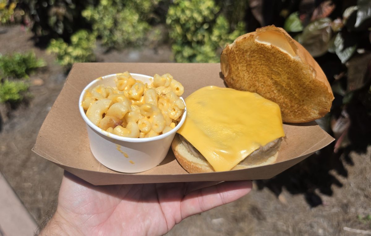 A Beyond Burger with melted cheese and an open top bun next to a cup of mac and cheese in a paper tray at Aquatica Orlando