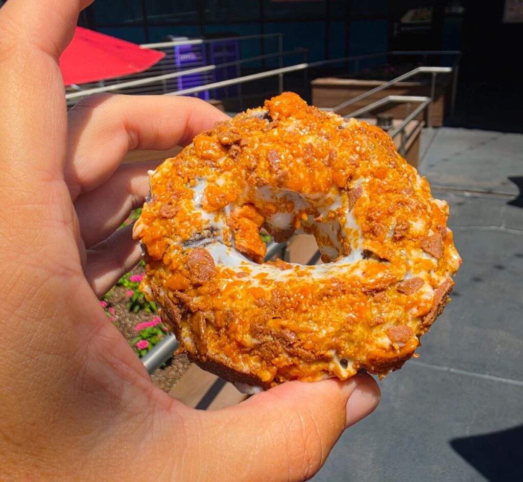 Close up of Voodoo Doughnut CityWalk Orlando Butterfinger doughnut topped with candy pieces