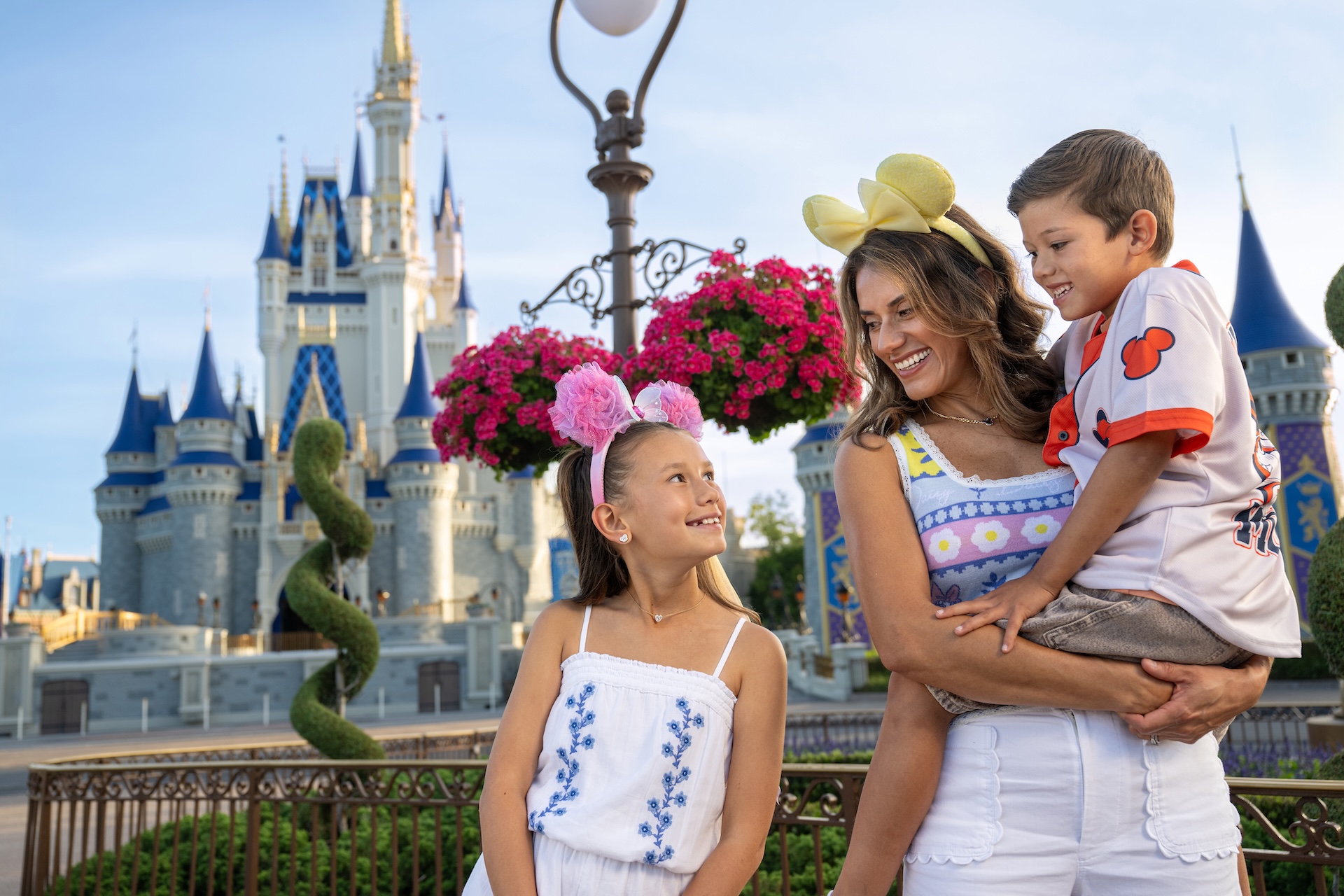 Disney World spring offers a promotional image with an adult and two kids in front of Cinderella Castle