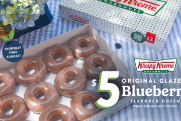 A box of Krispy Kreme doughnuts featuring a dozen original glazed blueberry doughnuts, with a floral arrangement and promotional text.