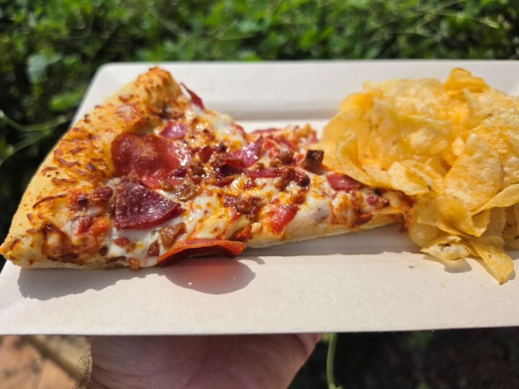 Meat Lovers Pizza shown on a white plate with chips
