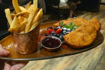 An alternate angle of the crispy, battered Monte Cristo sandwich served with fresh fruit, raspberry compote, and seasoned french fries for a Toothsome Chocolate Emporium review