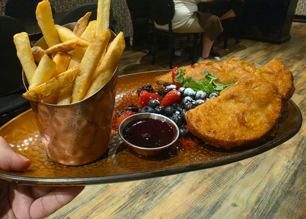 An alternate angle of the crispy, battered Monte Cristo sandwich served with fresh fruit, raspberry compote, and seasoned french fries for a Toothsome Chocolate Emporium review