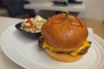 Close-up view of the signature Stack Burger on a toasted brioche bun for a Steakhouse 71 lunch review.
