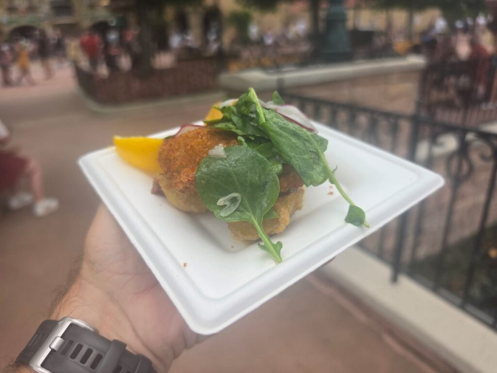 Wiener Schnitzel  with watercress on top held  at Epcot Food & Wine
