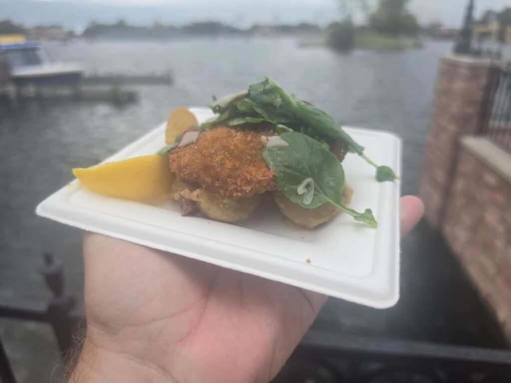 Wiener Schnitzel being help with the Epcot lagoon in the background 