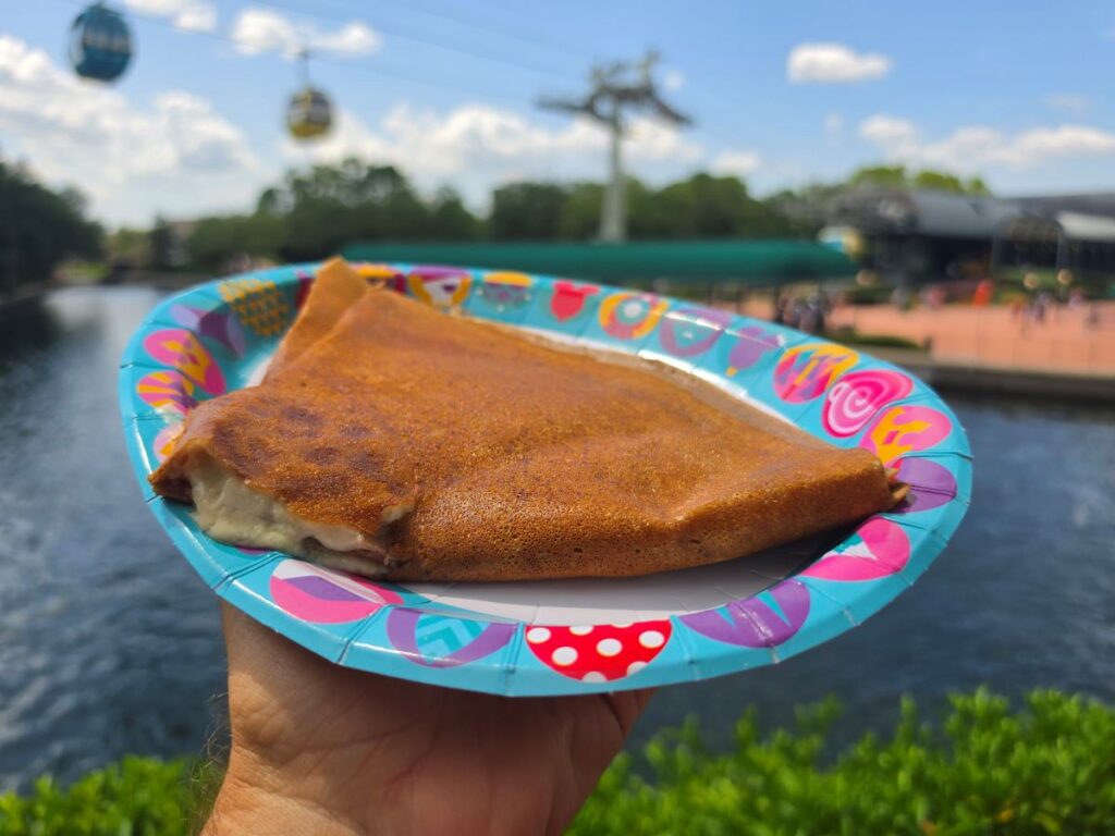 Cream of Brie Galette shown on an Epcot Disney plate with the Skyliner in the background