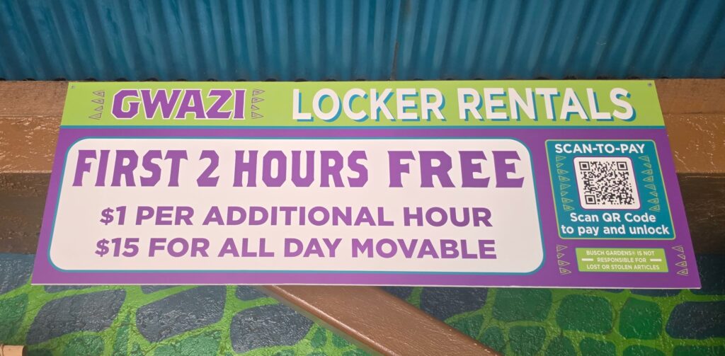 An Iron Gwazi free locker sign with purple and white text on a green background, featuring a QR code for payment and pricing for hourly or daily use.