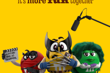 Three M&M's characters dressed as Marvel heroes—Deadpool, Wolverine, and She-Hulk—stand against a yellow background with a microphone overhead.